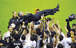 Hero; Jose Mourinho is lifted up by his Real Madrid players after their title triumph. Net photo.