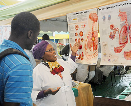 A nurse lectures to the public on health. The New Times / John Mbanda.