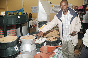 A man displays energy saving stoves at the recent entrepreneurship expo. The New Times / John Mbanda.