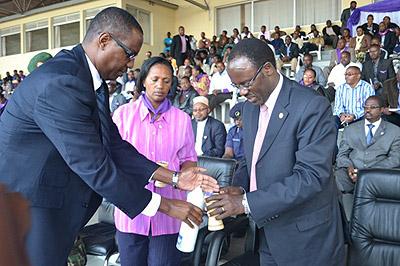 Culture and Sports minister Protais Mitali and Mayor Fidel Ndayisaba light a candle of hope aftre the Walk to remember at Nyamirambo stadium on Friday. The Sunday Times / T. Kisambira.