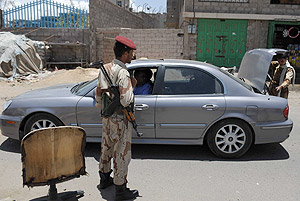 Yemeni soldiers check vehicles passing by on a street in Sanaa, Yemen.  Xinhua.