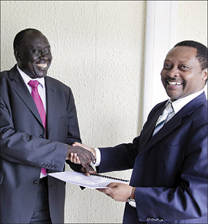 Minister of Justice Tharcisse Karugarama (L) exchanges documents with Prof Anastase Shyaka, CEO, Rwanda Governance Board . The New Times / Timothy Kisambira.