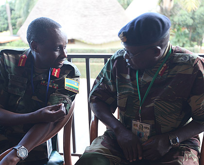 RDF Chief of Staff, Gen. Ceaser Kayizari, chats with the Chief of Staff of Zimbabwe Land Forces Gen. Martin Chindondo, yesterday in Munyonyo, Kampala. The New Times / G. Muramira.