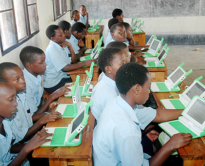 Primary school children using laptops. Over 200,000 units will have been distributed by the end of the year. The New Times / File.