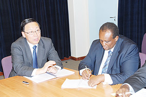 IFC Vice Presdient and treasurer, Jingdong Huo, (L) and IFC Country Representative Ignace Rusenga Mihigo Bacyaha addressing  journalists in Kigali. The New times / File.