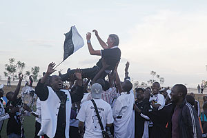 THANK YOU: Ernie Brandts is carried in the air by APR players as they celebrate winning their 13th league title on Friday.  The New Times / T. Kisambira.