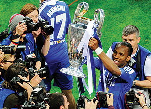 Chelsea's Ivorian forward Didier Drogba (R) celebrates with the trophy after the UEFA Champions League final. Net photo.