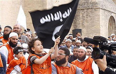 A young boy waves a black flag inscribed with Islamic verses at a rally of Tunisian Salafi Islamists in the central town of Kairouan May 20, 2012. Net photo