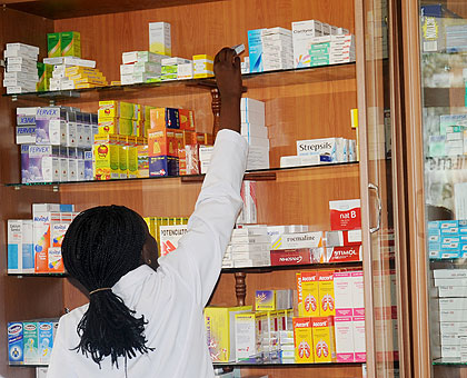 A Kigali pharmacist picking drugs from the shelf. A new report has warned against fake malaria drugs on the market. The New Times / File.