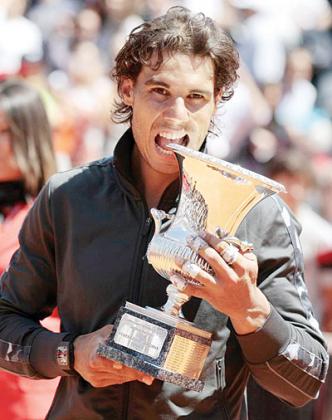 Rafael Nadal bites the trophy after winning his final match. Net photo.