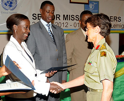 Foreign Affairs Minister Louise Mushikiwabo awards a certificate to Brig. Jane Spalding at the closure of a two-week UN Senior Mission Leadersu2019 Course in Kigali yesterday. Looking on is Defence Minister Gen. James Kabarebe. See story on page 2. The New Ti