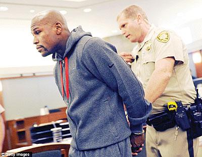 Floyd Maywether Jr is lead away in handcuffs as he surrenders to serve a three-month sentence. Net photo.