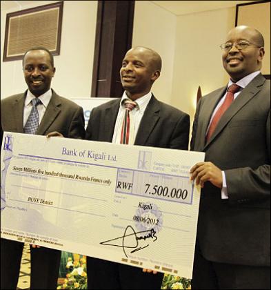 Huye District vice Mayor Cyprien Mutwarangabo  receives a  cheque from Local Government Minister James Musoni (R) and Southern Province Governor Alphonse Munyentali. Photo  T. Kisambira.