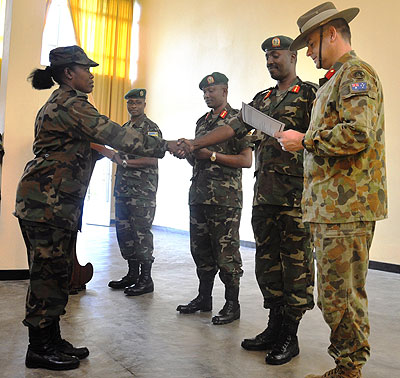 Gen Charles Kayonga conglatulates Uganda's Capt Hope Natukunda at the closure of the Millitary Observers Course at Rwanda Peace Academy. The New Times / S.Nkurunziza.