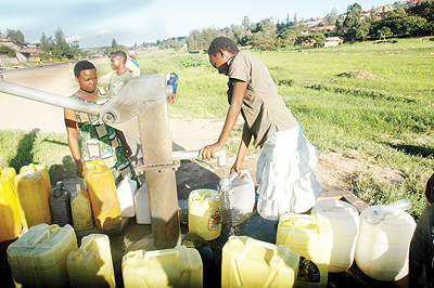 WATER IS LIFE. Residents queue at a water pump. The New Times / File.