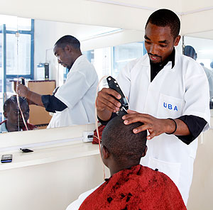 A barber shaving a customer in a Kigali saloon. The academy should boost the sector. The New Times / Timothy Kisambira.