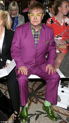 Green with envy. Sir Elton John stood out in his front row seat at at a catwalk show in London today in a pair of bright metallic loafers.