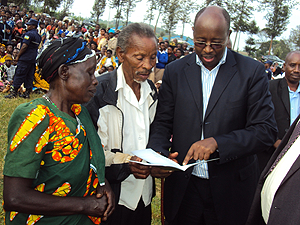 The family performance notebook was launched in February by the Minister of Local Government James Musoni (R). The New Times / File.