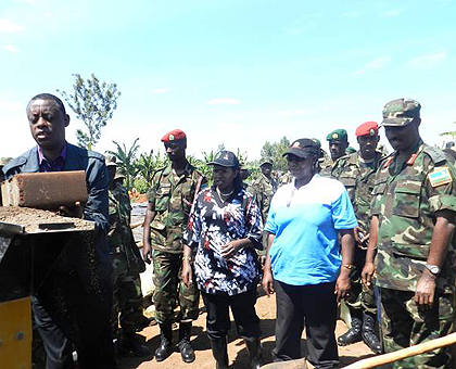 Gen. Kabarebe working on a brick-making machine. Beside him is Gen. Kayonga and Eastern Province Governor, Odette Uwamariya. The Sunday Times / File.