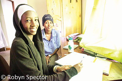 Usher Irakoze (one writting) and Rosalie Umuhoza revising their school notes. 