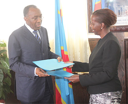 Foreign minister Louise Mushikiwabo (R) and her Congolese counterpart Raymond Tshibanda exchange files after bilateral talks in Kinshasa on June 19. The New Times / Courtesy.