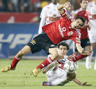 Al-Ahlyu2019s Mohamed Barkat (top) fights for the ball with El Zamaleku2019s Omar Gabr during their Egyptian Premier League derby soccer match at Cairo Stadium. Net photo