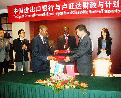 Finance Minister, John Rwangombwa, exchanging files with Sun Ping, the Vice President of Exim Bank of China, after signing the agreement. The New Times / F. Kanyesigye.