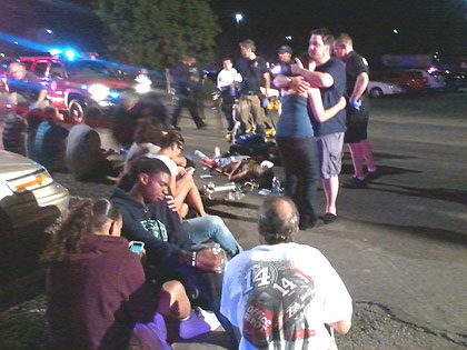 Victims are tended to in the parking lot of the aurora theater where a mass shooting occurred during the primere of the dark-night rises. Net Photo.