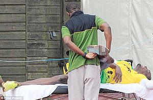 Olympic tripple goal medalist Bolt grimaces as his physio goes to work. Net photo.