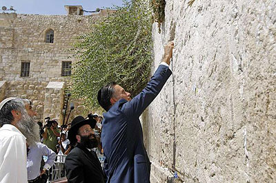 Romney places a prayer note as he visits the Western Wall in Jerusalem. Net photo.