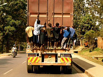 Street boys mount a truck on a Kigali street. Photo /Vlad Dandu.