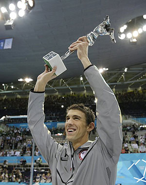 Phelps holds up a silver trophy after being honored as the most decorated Olympian.  Net photo.