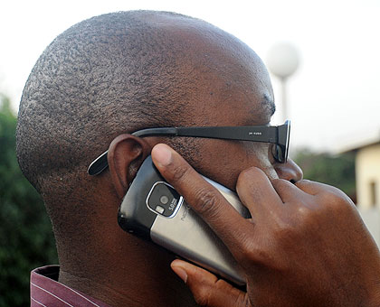 A man busy on phone. There will be cases that may neccessitate tapping of some calls. The New Times / Timothy Kisambira.