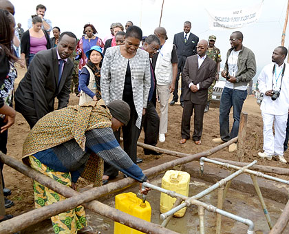 Amos (C) visits a water facility at Kigeme camp. The New Times / JP Bucyensenge.