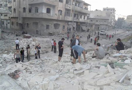 Members of the Free Syrian Army inspect a damaged building after clashes with President  Bashar al-Assads forces. Net photo.