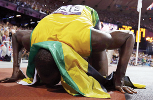 Bolt plants a kiss on the track after his sensational triumph.  Net photo.