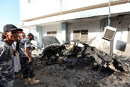 Libyan security forces inspect the remains of a vehicle near the Ministry of Interior in Tripoli after twin blasts killed two people in the Libyan capital. Net photo.