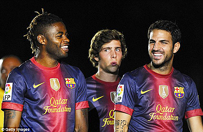 Alex Song (L) jokes with his new Barcelona team-mate Cesc Fabregas  (R) at the Nou Camp. Net photo.