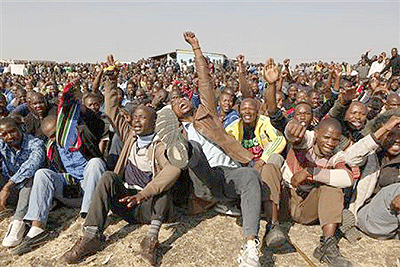 Striking miners hold up their hands as they are addressed by former African National Congress Youth League (ANCYL) President Julius Malema outside a South African mine in Rustenburg. Net photo.