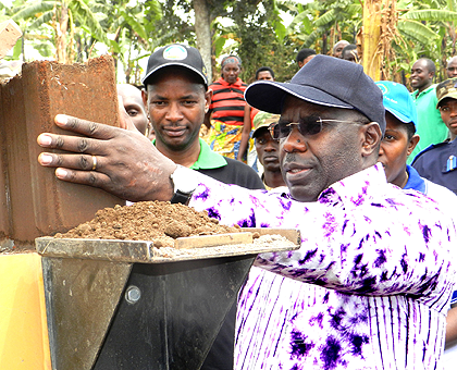 Prime Minister Pierre Damien Habumuremyi lifts a block from a hydrafoam machine during Umuganda in Rwamagana District Yesterday. The Sunday Times / Steven Rwembeho.