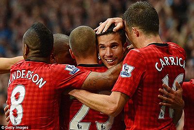 Van Persie is mobbed by his team-mates after scoring for Manchester United. Net photo.