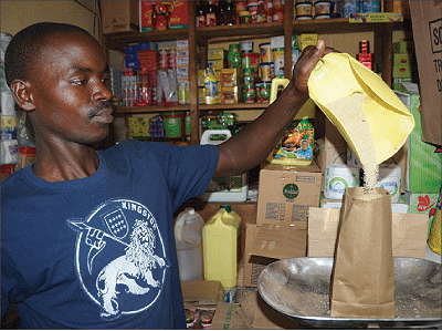 A shop attendant packaging suger in a manila envelope. Exporters have said that importation of packaging materials is hurting their businesses. The New Times / File.