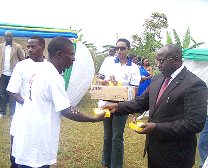 PM Habumuremyi hands over a mobile phone to a member of a community policing commitee, Thursday. The sets are expected to enhnance crime alert. The New Times/JP Bucyensenge.