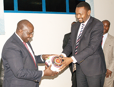 The Prime Minister Pierre Damien Habumuremyi receives a souvenir ball from Ferwafau2019s vice president Raoul Gisanura during his visit to the federation headquarters on Wednesday. The New Times/E. Niyonshuti.