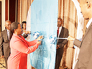 National Bank of Rwanda Vice Governor, Monique Nsanzabaganwa (L) cuts a ribbon after Unguka was handed a licence to operate as a microfinance bank. The New Times / File.