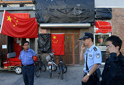 Police walk past a closed Japanese restaurant covered with Chinese national flags as anti-Japanese protests continued outside the Japanese Embassy in Beijing over the Diaoyu islands issue. AFP