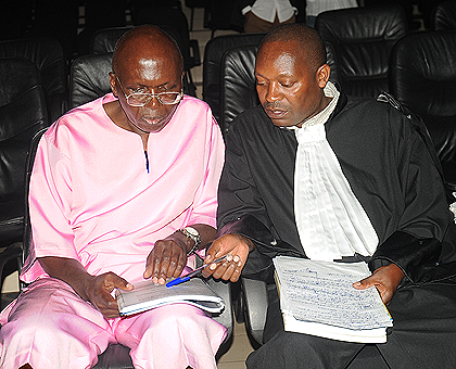 Leon Mugesera consults with his lawyer Felix Rudakemwa in court on Monday. The New Times / John Mbanda.