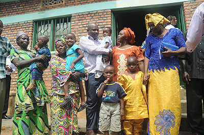 Parents pose with the orphans they adopted from Mpore Pefa Orphanage in Gikondo, a Kigali suburb recently. The New Times / File..