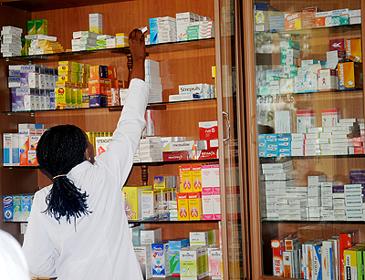 A Pharmacist picks drugs from the shelf. The New Times / File.