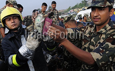 Nepalese fireman and rescue workers show a passport and money collected from the wreckage of a Sita airplane after it crashed in Manohara, Bhaktapur on the outskirts of Kathmandu on September 28. AFP photo.